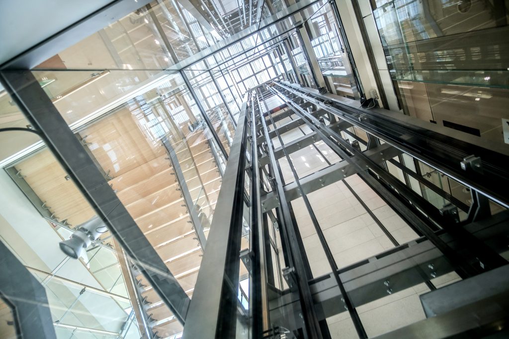 Vista interna de elevador panorâmico e estrutura de trilhos
